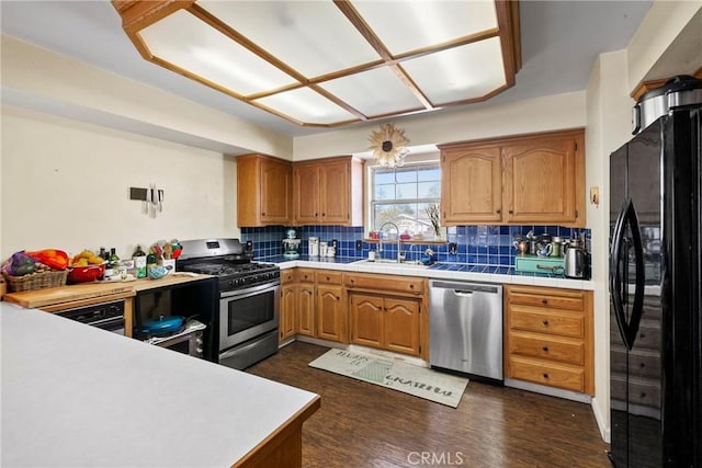 kitchen featuring backsplash, sink, dark hardwood / wood-style flooring, and appliances with stainless steel finishes