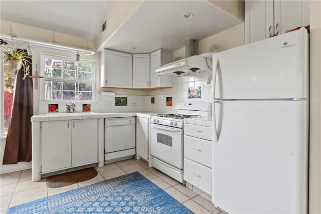 kitchen featuring white cabinetry, tile counters, exhaust hood, and white appliances