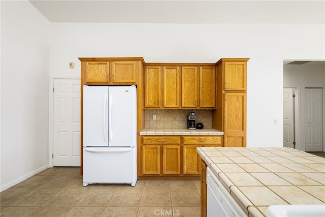 kitchen featuring white appliances, tile countertops, tasteful backsplash, and light tile patterned flooring