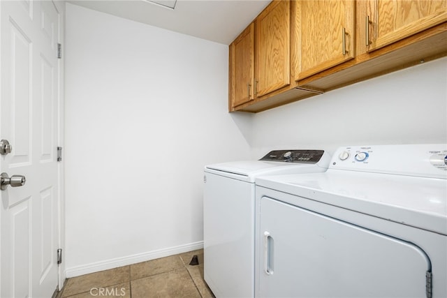 washroom featuring cabinets, light tile patterned floors, and washing machine and dryer