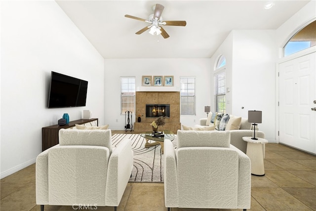 living room featuring ceiling fan, light tile patterned flooring, and a tile fireplace