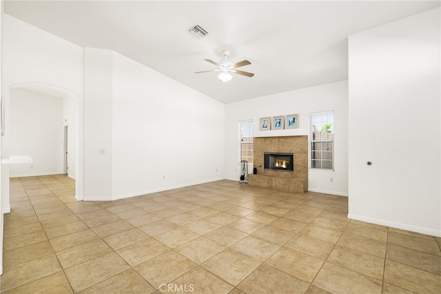 unfurnished living room featuring ceiling fan, light tile patterned floors, and a tiled fireplace