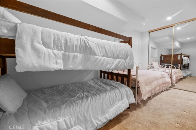 bedroom with a closet, light colored carpet, and lofted ceiling