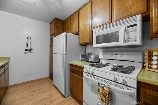 kitchen with light wood-type flooring and white appliances