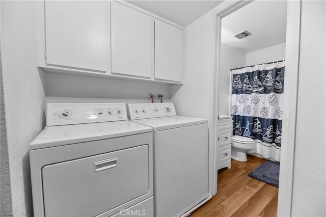 laundry room with light hardwood / wood-style flooring, cabinets, and independent washer and dryer