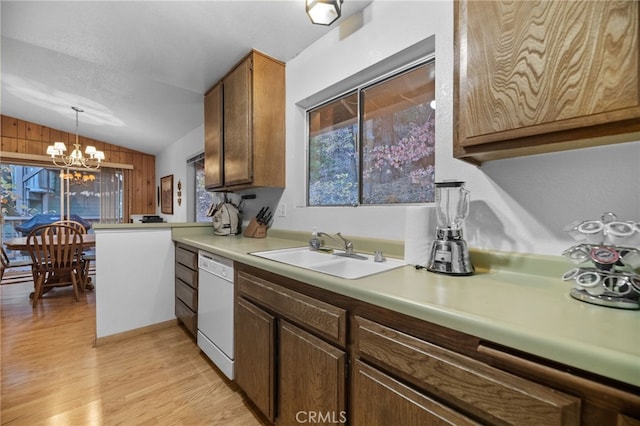 kitchen featuring vaulted ceiling, sink, decorative light fixtures, dishwasher, and a chandelier