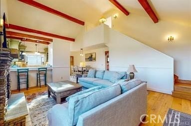 living room with beam ceiling, high vaulted ceiling, and light wood-type flooring