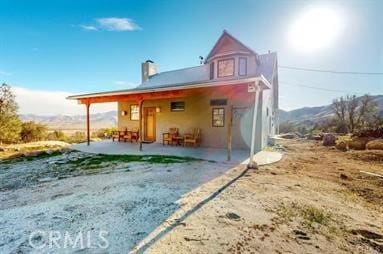 rear view of property with a mountain view and a patio