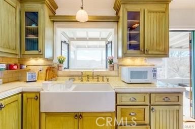 kitchen with backsplash, decorative light fixtures, and sink