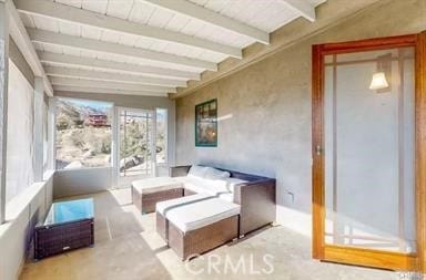 sunroom / solarium featuring beam ceiling