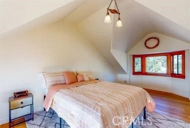 bedroom featuring wood-type flooring and lofted ceiling