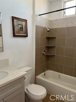 full bathroom featuring vanity, toilet, and tiled shower / bath