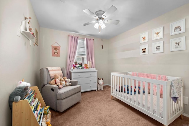 carpeted bedroom featuring ceiling fan and a nursery area