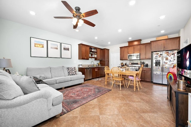 living room with ceiling fan, light tile patterned floors, and sink