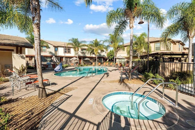 view of swimming pool featuring a hot tub and a patio area