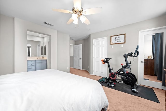 carpeted bedroom with ensuite bathroom, sink, and ceiling fan