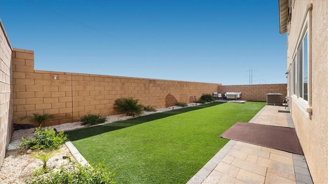 view of yard with central AC and a patio area