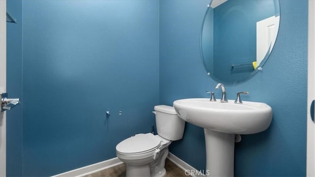 bathroom featuring hardwood / wood-style flooring and toilet