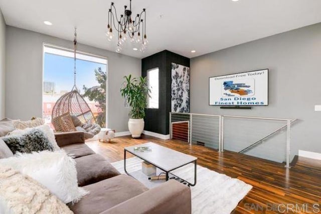 living room with dark hardwood / wood-style flooring and an inviting chandelier