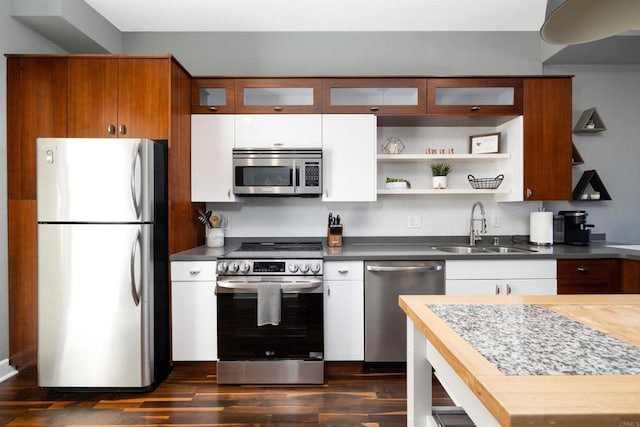 kitchen featuring dark hardwood / wood-style flooring, white cabinetry, sink, and appliances with stainless steel finishes