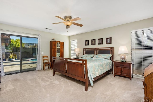 bedroom with multiple windows, ceiling fan, light colored carpet, and access to exterior