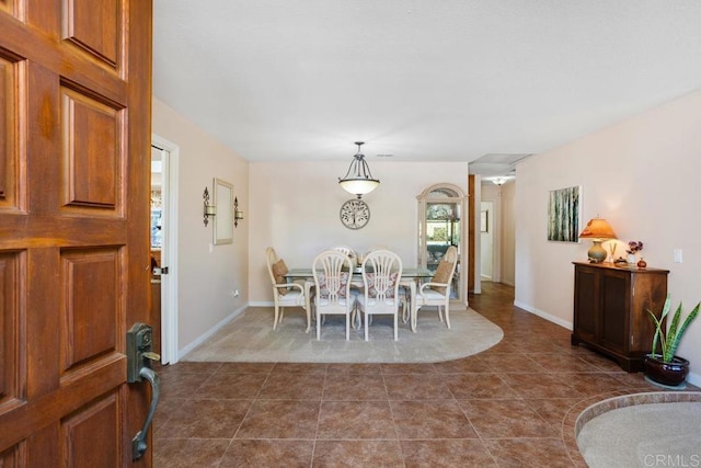 dining space featuring dark tile patterned floors