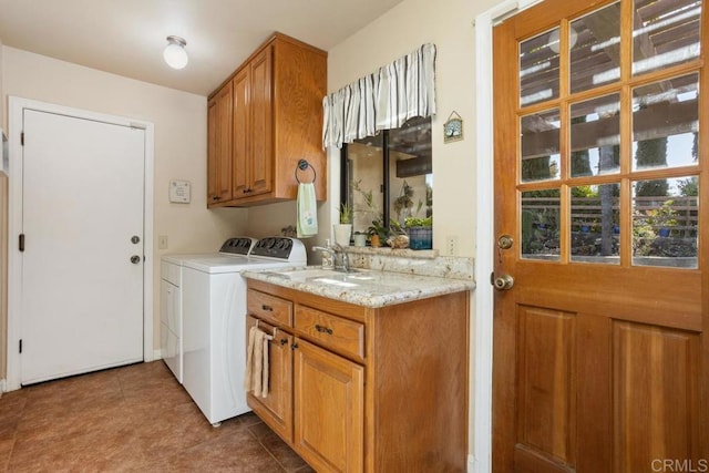 laundry area featuring tile patterned floors, cabinets, sink, and washing machine and dryer