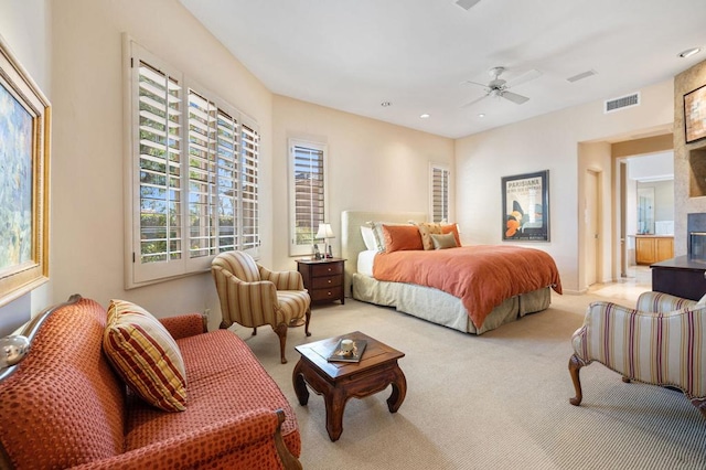 carpeted bedroom featuring ceiling fan and a fireplace