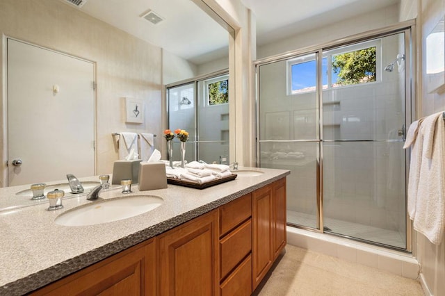 bathroom with an enclosed shower, vanity, and plenty of natural light