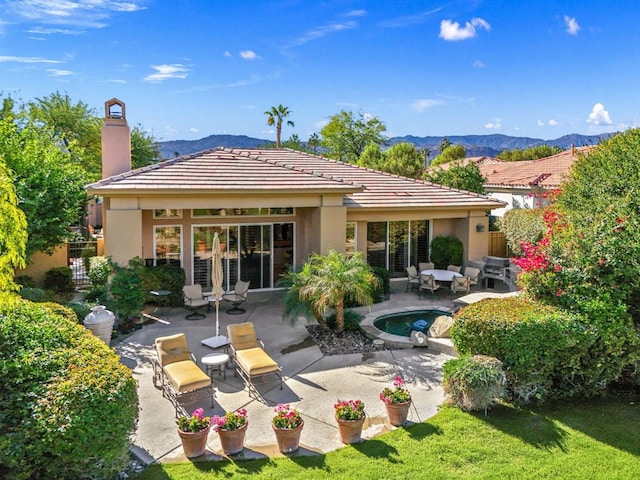 rear view of property featuring a mountain view and a patio area