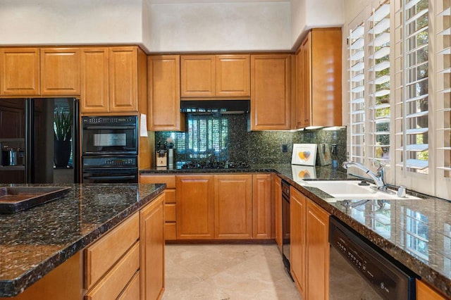 kitchen with sink, tasteful backsplash, dark stone countertops, and black appliances