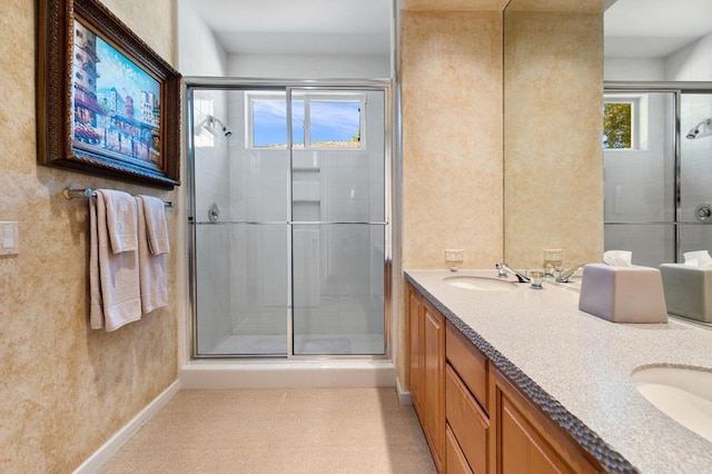 bathroom with vanity, walk in shower, and a healthy amount of sunlight