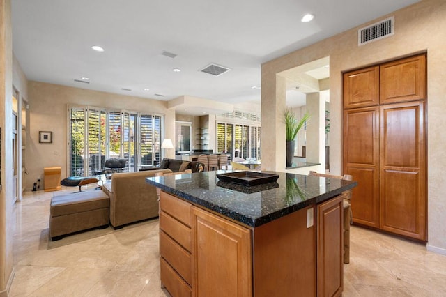 kitchen with a kitchen island and dark stone countertops