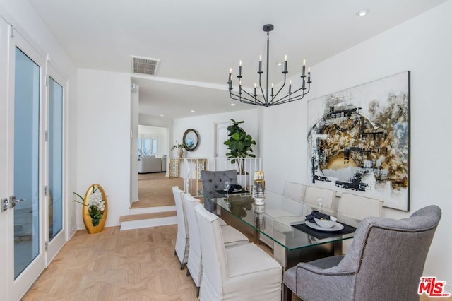 dining area featuring light parquet flooring and a chandelier