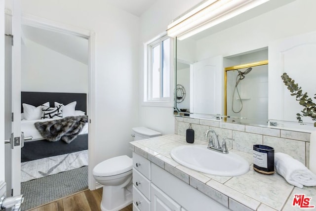 bathroom with decorative backsplash, walk in shower, vanity, wood-type flooring, and toilet