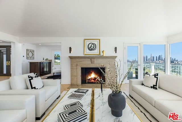 living room featuring light wood-type flooring and a high end fireplace