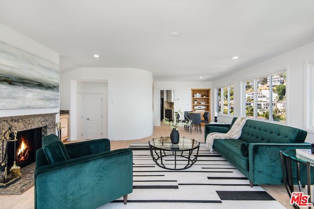 living room featuring light hardwood / wood-style floors and a high end fireplace