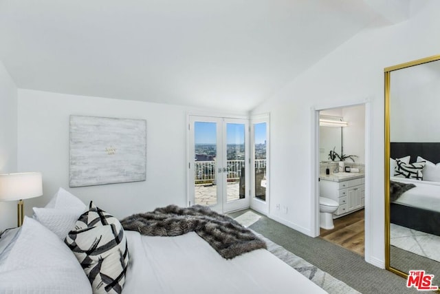 bedroom featuring access to exterior, french doors, ensuite bath, vaulted ceiling, and dark wood-type flooring