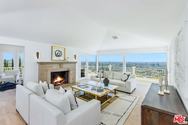 living room featuring a wealth of natural light, light parquet floors, and a high end fireplace