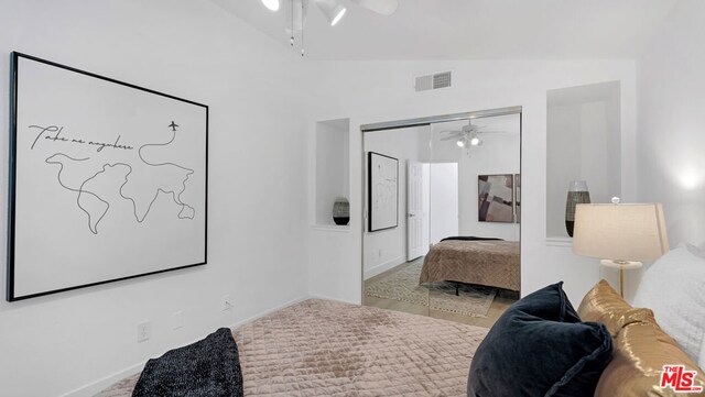 bedroom with light carpet, vaulted ceiling, and a closet