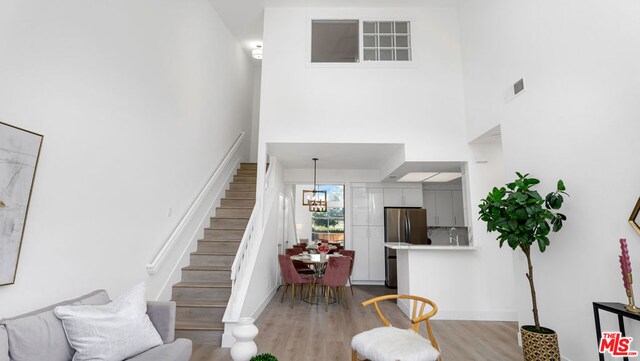 stairway featuring hardwood / wood-style floors and an inviting chandelier