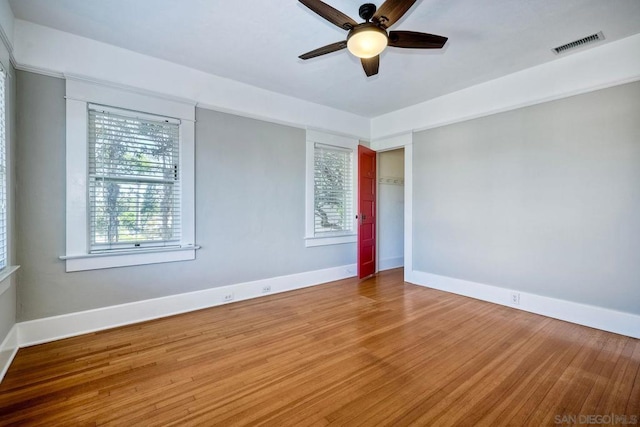 empty room with hardwood / wood-style flooring and ceiling fan