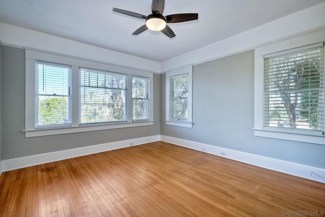 empty room featuring ceiling fan, a healthy amount of sunlight, and wood-type flooring