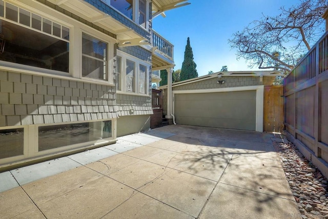 view of side of home featuring a balcony, an outdoor structure, and a garage