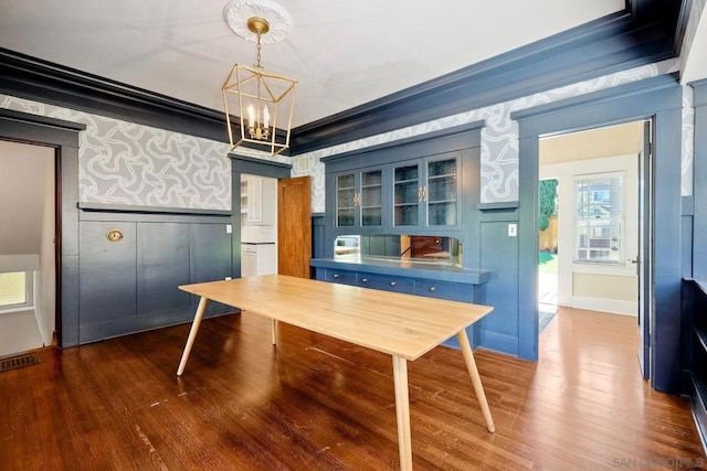 unfurnished office with crown molding, a chandelier, and dark hardwood / wood-style floors