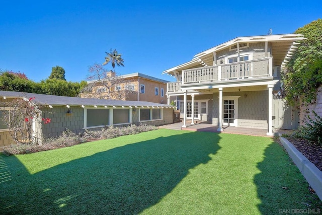 back of house with a yard, a balcony, and a patio