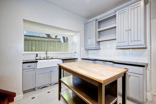 kitchen with gray cabinetry, decorative backsplash, and sink