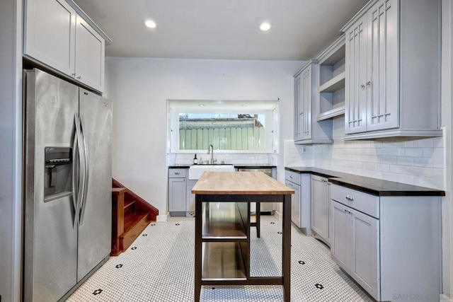 kitchen with wooden counters, appliances with stainless steel finishes, tasteful backsplash, gray cabinetry, and sink