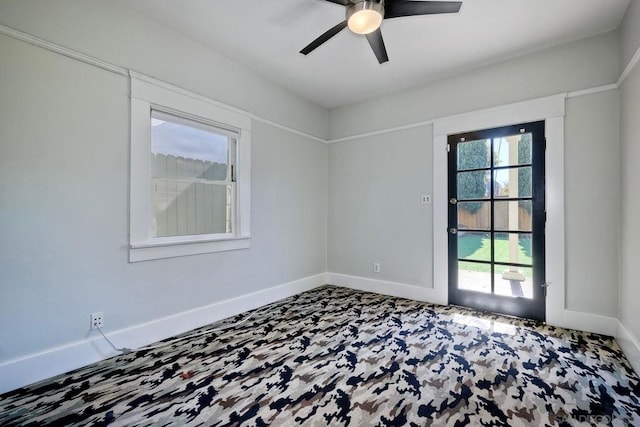 unfurnished room featuring a wealth of natural light and ceiling fan