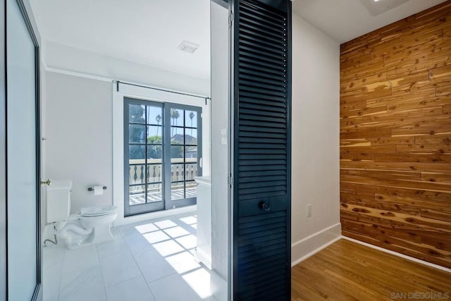 doorway to outside featuring hardwood / wood-style floors and wood walls